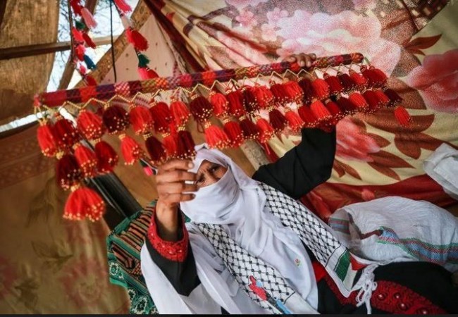 سيدة فلسطينية تغزل الصوف بقرنيْ غزال